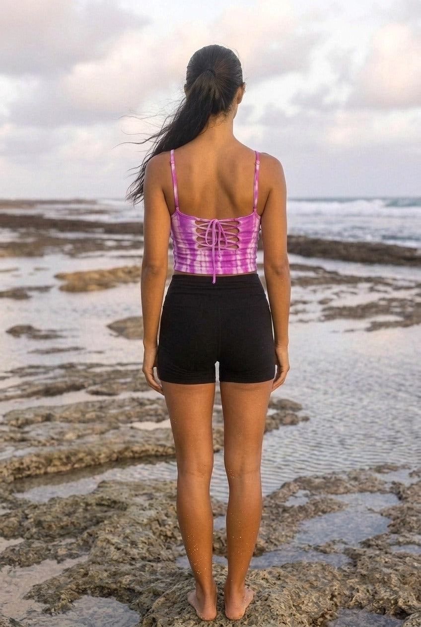 Back view of the Pink Cross Back Yoga Tank showing the lace up cross back detail, worn with black shorts